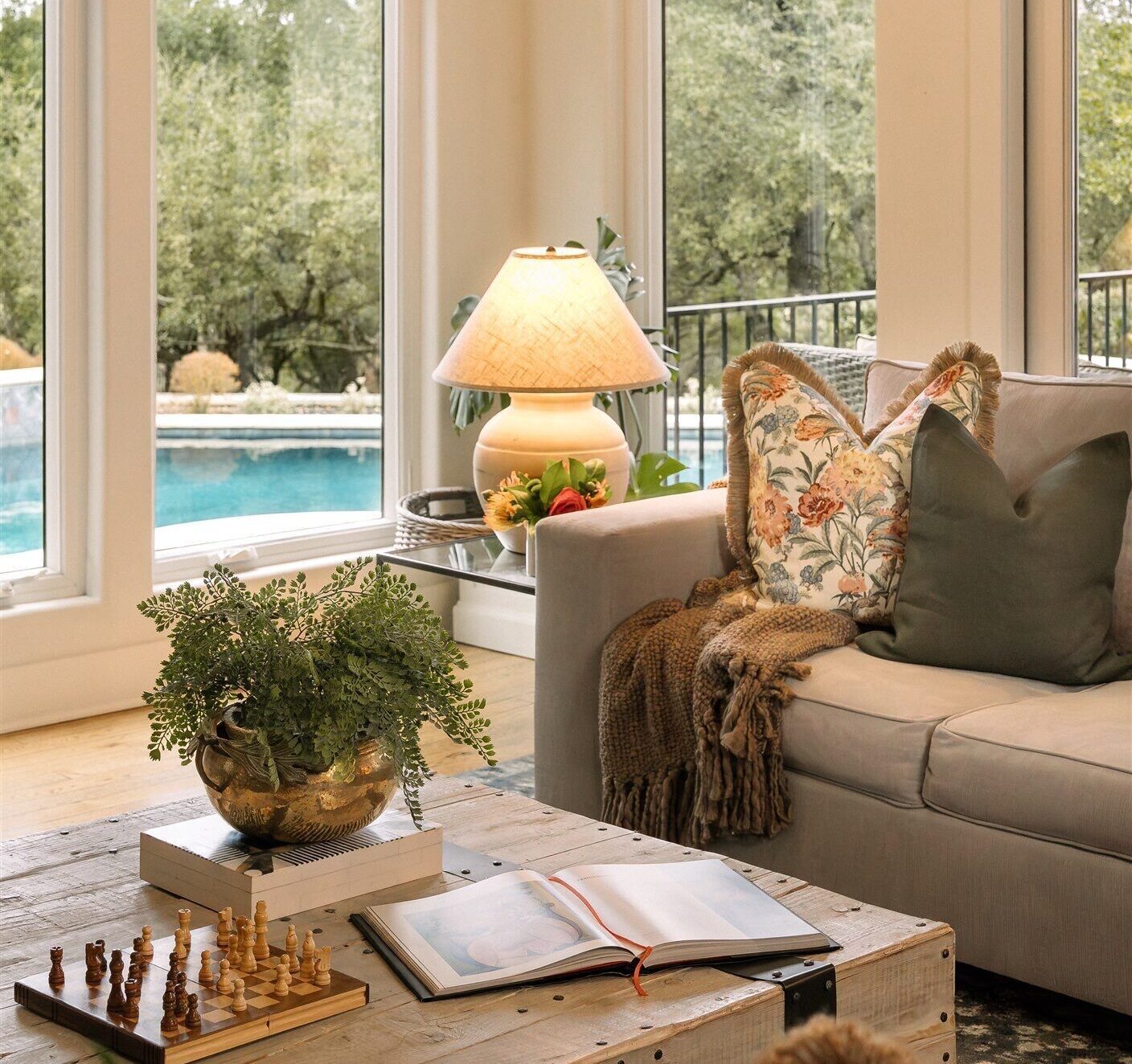 Living room designed by Rachel Jackson Design with a pool view and layered table styling