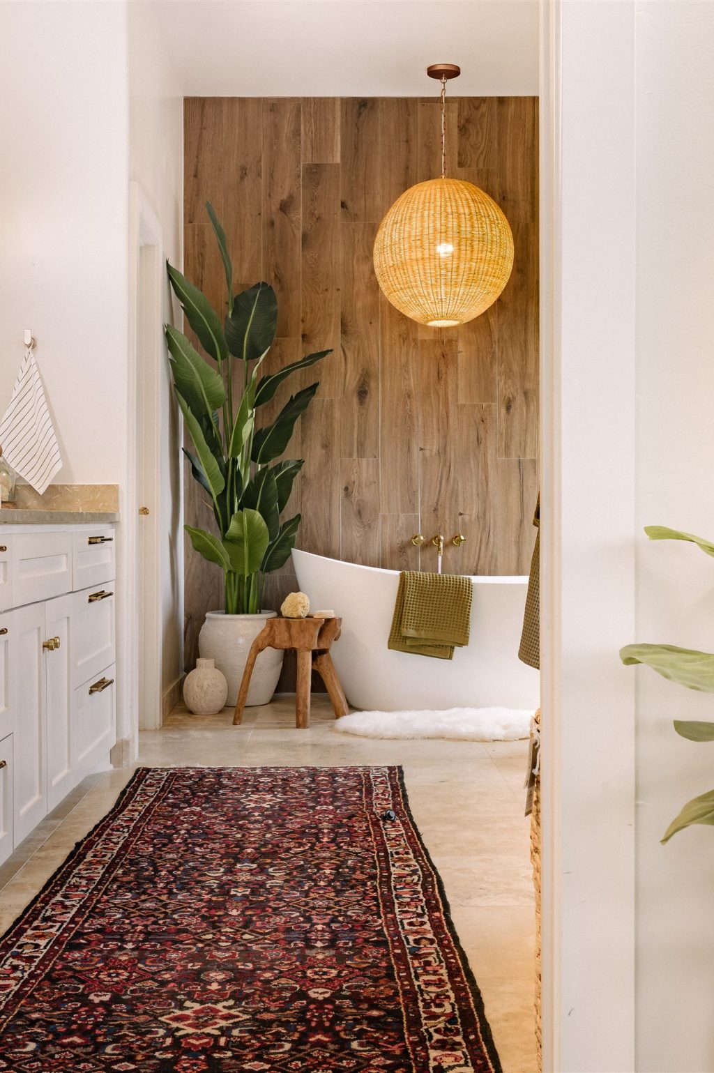 Primary bathroom designed by Rachel Jackson Design with a freestanding tub and wood accent wall, featured in Good Housekeeping May/Jun '26